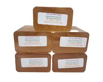 Op de afbeelding: Een stapel van zes rechthoekige honingkleurige zeepblokken. Elk blok heeft een wit etiket met de tekst "The Gourmet Rose", websiteadres en "1 lb GRADE A HONEY Natural Melt And Pour Soap".