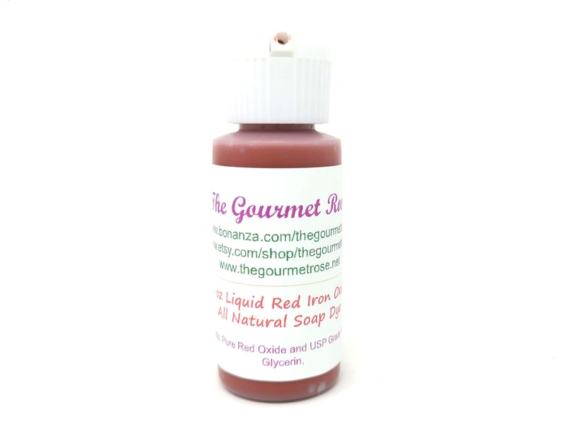 May include: A small bottle of liquid red iron oxide soap dye. The bottle has a white cap and a label with the text "The Gourmet Rose" and product information. The dye is all natural and contains red oxide and glycerin.