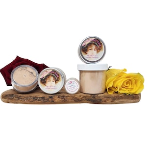 May include: A collection of The Gourmet Rose makeup products, including concealer foundation, displayed on a wooden board. The products are in various containers, with a red rose and a yellow rose adding color. The text "#40 Light 2-in-1 Concealer Foundation" is visible.