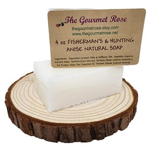 Könnte beinhalten: Ein weißes, rechteckiges Stück Anis Naturseife, beschriftet mit "Fisherman's & Hunting", liegt auf einer kleinen, runden Holzscheibe. Das Etikett mit dem Text "The Gourmet Rose" listet die Inhaltsstoffe und das Gewicht der Seife, 113 g.