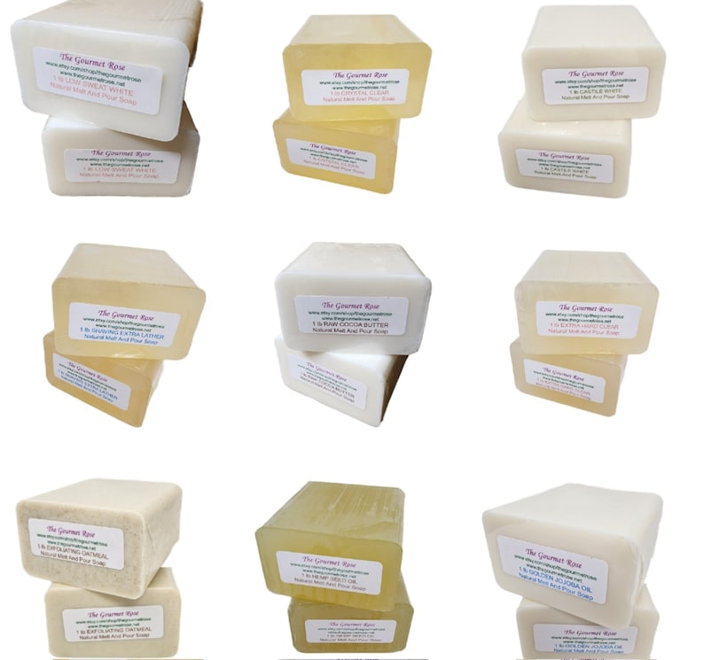 May include: Nine rectangular bars of natural melt and pour soap in various colors, stacked in pairs. Each bar has a label with the brand name "The Gourmet Rose" and product information. The soaps range in color from white to clear and amber.