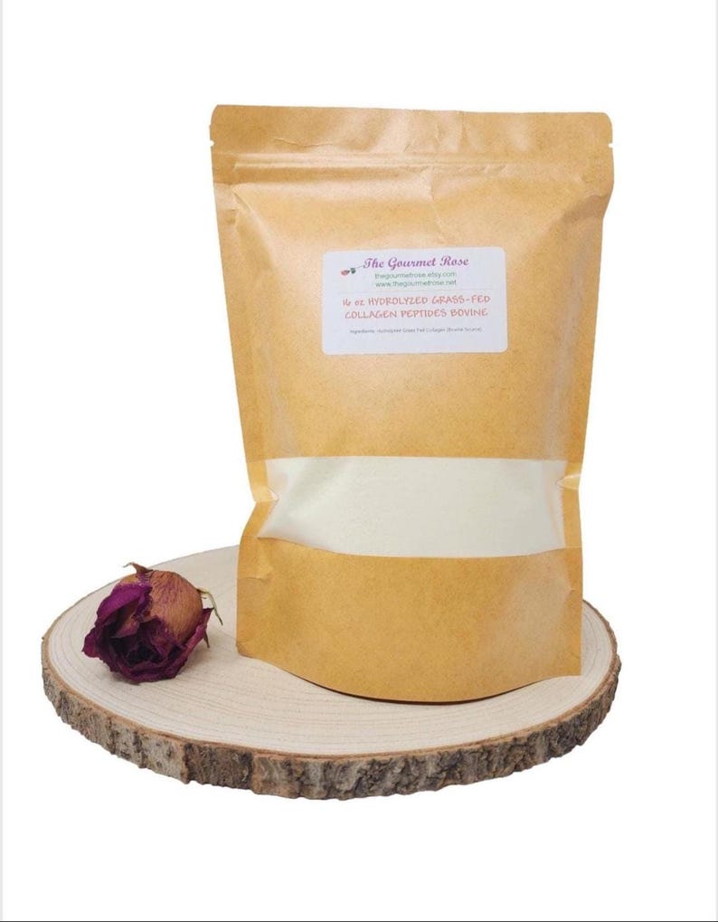 May include: A brown paper bag of collagen peptides with a clear window, labeled "The Gourmet Rose." A dried, dark purple rose sits on a wooden slice next to the bag. The label reads "6 oz Hydrolyzed Grass-Fed Collagen Peptides Bovine."