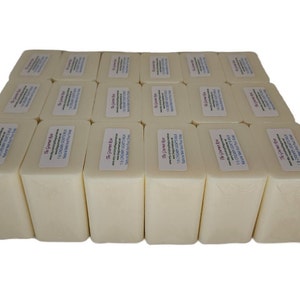 May include: An array of rectangular, cream-coloured soap bars, each with a label. The labels display text including "Creamy Goat's Milk" and "Natural Melt and Pour Soap". The soap bars are arranged in neat rows.