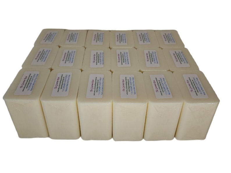 May include: An array of rectangular, cream-coloured soap bars, each with a label. The labels display text including "Creamy Goat's Milk" and "Natural Melt and Pour Soap". The soap bars are arranged in neat rows.