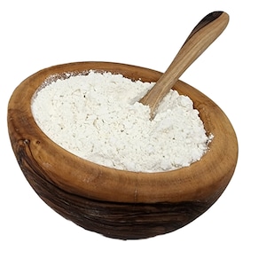 Può includere: Una ciotola di legno piena di farina bianca, con un cucchiaio di legno all'interno. La ciotola è fatta di legno marrone chiaro con venature visibili. La farina è di colore bianco sporco.
