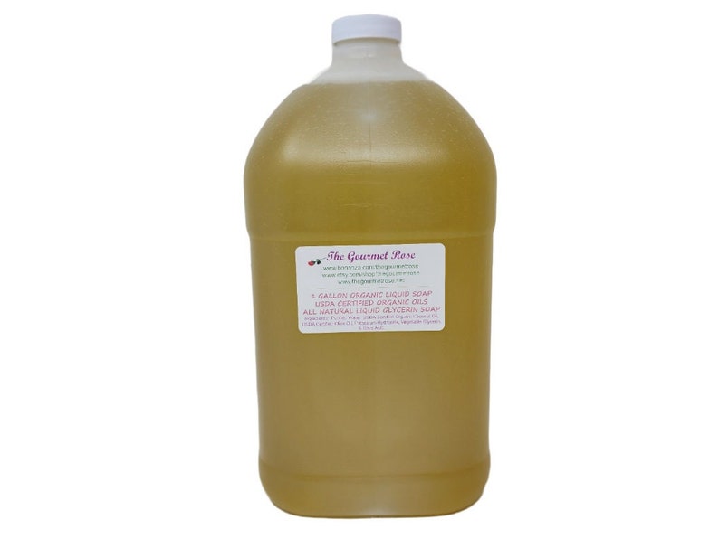 Peut inclure: Une grande bouteille en plastique transparente remplie d'un liquide dor&eacute;. Le bouchon est blanc. L'&eacute;tiquette indique "The Gourmet Rose" et "2 Gallon Organic Liquid Soap". Le savon est probablement &agrave; base de glyc&eacute;rine.
