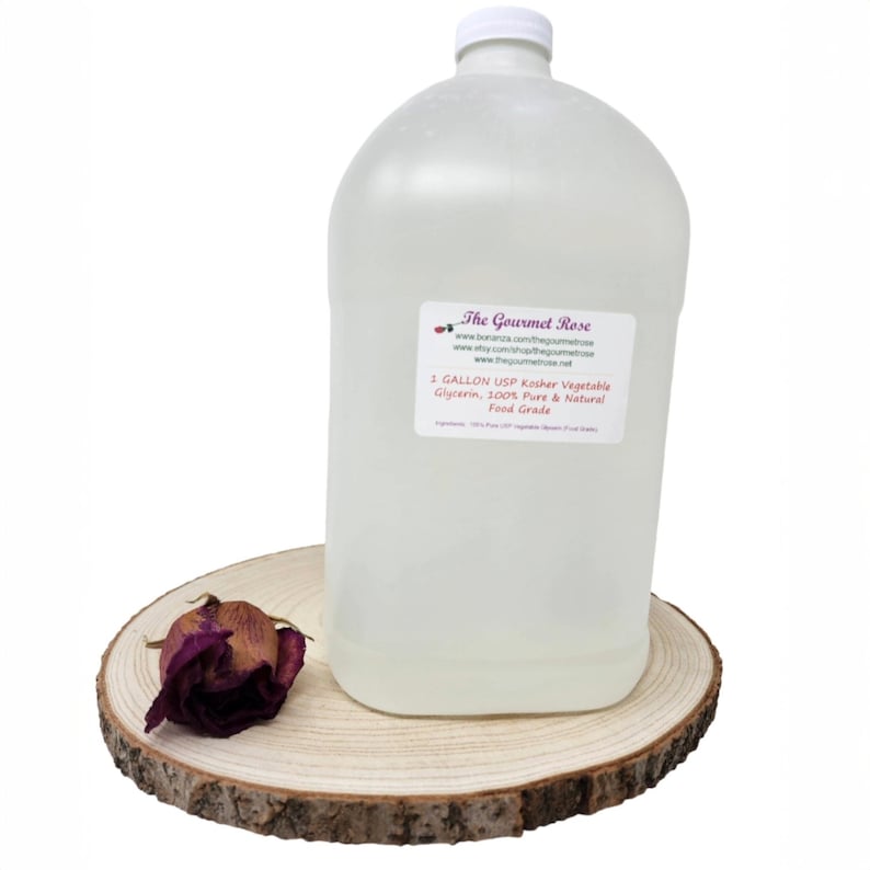 May include: A large, clear plastic jug with a white cap, labeled "The Gourmet Rose" and "1 GALLON USP Kosher Vegetable Glycerin." The jug sits on a wooden slice with a dried rose. The product is described as 100% pure and natural, food grade.