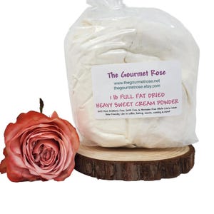 Puede incluir: Una bolsa de plástico transparente que contiene polvo blanco, etiquetada como "1 lb FULL FAT DRIED HEAVY SWEET CREAM POWDER", se encuentra sobre una rodaja de madera. A la izquierda hay una rosa rosa. La etiqueta dice "The Gourmet Rose".