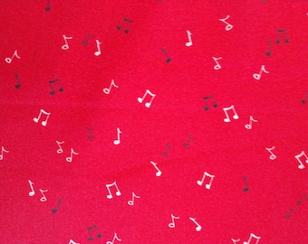Puede incluir: Tela roja con un patrón de notas musicales dispersas. Las notas son blancas y negras, creando un diseño contrastante. Las notas musicales están en varios tamaños y orientaciones.