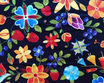 Puede incluir: Una tela con fondo azul oscuro que presenta un colorido estampado floral. El diseño incluye fresas rojas, bayas azules y varias flores en tonos rojos, amarillos, naranjas y azules. Hojas y tallos verdes completan el diseño.