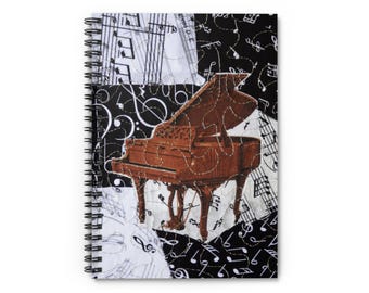 Puede incluir: Cuaderno de espiral con un diseño de collage musical. La portada muestra una ilustración de un piano de cola marrón, sobre un fondo de notas musicales y partituras en blanco y negro. El diseño del cuaderno es artístico y temático musical.