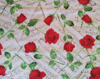 Puede incluir: Tela con un diseño de rosas rojas con hojas y tallos verdes, sobre un fondo de partituras antiguas. Las rosas están en plena floración y dispersas sobre el fondo color crema.