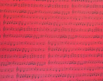 Puede incluir: Una superficie de tela o papel de color rojo vibrante con un patrón repetitivo de notación musical negra. El diseño consiste en pentagramas horizontales con varias notas musicales, claves y símbolos impresos en tinta negra.