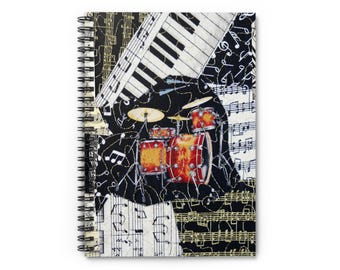 Puede incluir: Cuaderno de espiral con un diseño musical. La portada presenta un collage de un teclado de piano, una batería y notas musicales en negro, blanco y rojo. Las páginas del cuaderno son blancas.