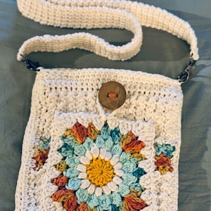 Bolso bandolera hecho a mano en crochet. Color crema, cierre de cremallera y bolsillo cuadrado Sunburst Grandma con cierre de botón en la parte delantera.