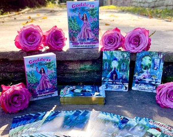 May include: A deck of 54 oracle cards with a pink and blue color scheme. The cards feature illustrations of a woman in a flowing gown, a castle, and a garden. The box for the cards is pink and features the text "Goddess of Healing and Love" and "Within Your Goddess Power".