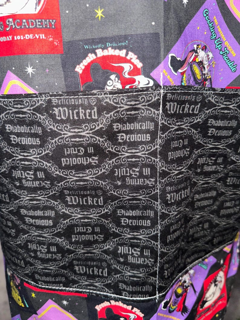 May include: Close-up of a fabric item with a black and gray pattern featuring the word "Wicked" and phrases like "Diabolically Devious." The design includes images and text from a cartoon, with a red and purple color scheme.