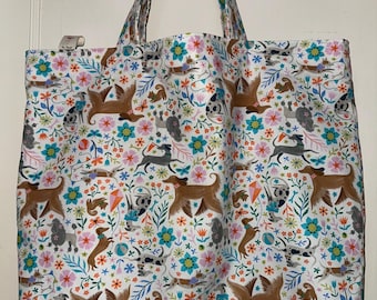 Bolsa de tela lavable y reversible hecha a mano con perritos jugando entre las flores en primavera.