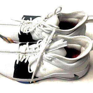 May include: Pair of white athletic shoes with black accents and white laces. The shoes have a low-top design with a pull tab on the heel. The soles have a multi-colored design.