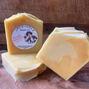 May include: Three bars of yellow soap with a white label that says "Jack + Cole Soap Co. Brass Monkey" with a cartoon monkey holding a microphone.