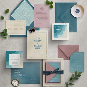 May include: A wedding invitation suite with a blue and white color scheme. The invitation features a watercolor-style design of ocean waves and the text "Alex & Charlie". The save the date card features a blue and white seashell design. The details card features a pink background with a seashell design.