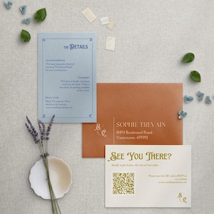 May include: A white card with gold text that says "See You There?" and a QR code. The card also includes the text "Kindly RSVP before the 5th of November" and "Please scan the QR code to RSVP on our website: www.weddingwebsite.com".