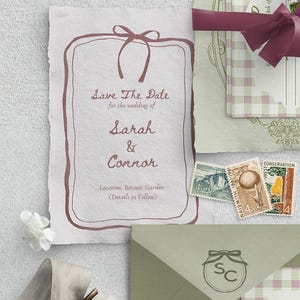 K&ouml;nnte beinhalten: Save-the-Date-Karte mit rustikalem, handgezeichnetem Design. Die Karte ist mit einem braunen Band verziert und tr&auml;gt den Text "Save The Date" f&uuml;r die Hochzeit von Sarah & Connor. Der Ort ist als Botanischer Garten angegeben, die Details folgen.