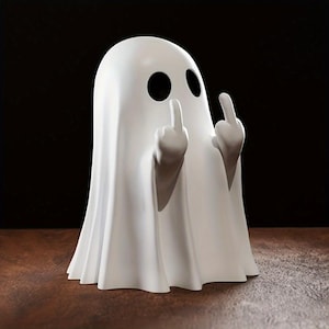 Peut inclure: Figurine de fantôme blanc avec des trous noirs pour les yeux, faisant un geste grossier avec les deux mains. Le fantôme est posé sur une surface marron sur fond sombre. Une version humoristique d'une figure d'Halloween.