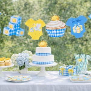 May include: A baby shower table setting with a two-tiered cake, cupcakes, and cookies. Decorations include a banner of baby clothes and blocks, all in blue and yellow. The theme is a sunny day with a cheerful vibe.