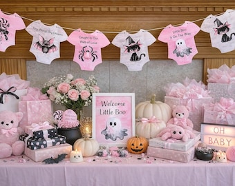 Może przedstawiać: Różowa dekoracja na baby shower z motywem Halloween. Różowe pajacyki z upiorną grafiką wiszą nad prezentami, dyniami i pluszakami. Znak głosi "Welcome Little Boo", a podświetlany napis "OH BABY".