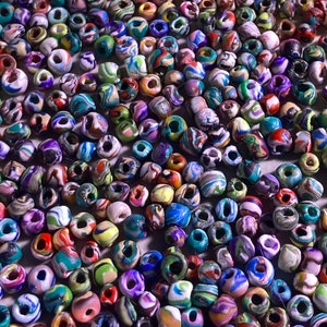 May include: A large collection of colorful, swirled glass beads. The beads are all different sizes and shapes, and they are arranged in a random pattern. The beads are perfect for making jewelry or other crafts.