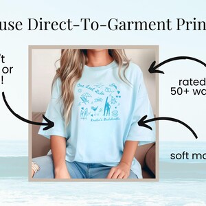 May include: A light blue t-shirt with a graphic design featuring the text "One Last Ride" and various illustrations. The shirt is made with a soft material and is rated for 50+ washes.