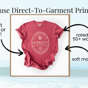 May include: A red t-shirt with the text "HOUSE OF O'BRIEN" in a circular design. The shirt is made of soft material and is rated for 50+ washes. The image also states that the shirt uses Direct-To-Garment printing.