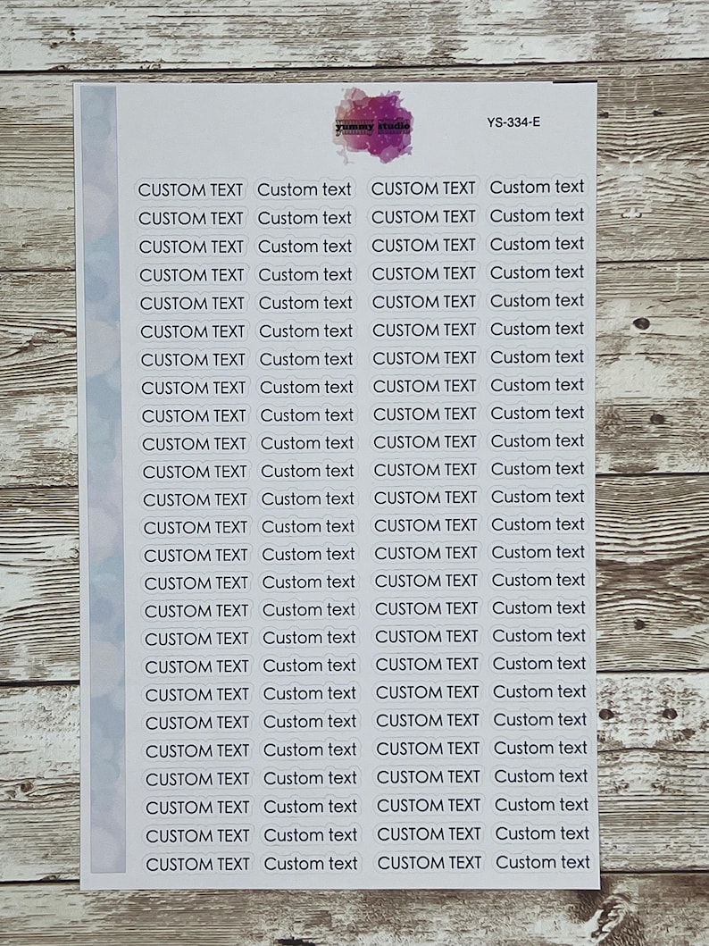 May include: A sheet of white paper with 24 white oval stickers. Each sticker has the text "CUSTOM TEXT" printed in black, followed by the words "Custom text" in a smaller font.