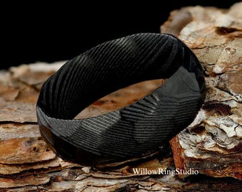 May include: Black ring with a textured, grooved surface. The ring is made of a durable material and has a sleek, modern design.
