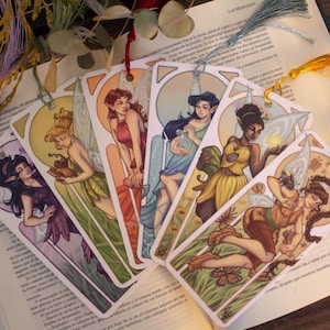 Puede incluir: Conjunto de seis marcapáginas coloridos con ilustraciones de hadas con alas. Cada marcapáginas tiene un diseño de hada diferente con un esquema de color único y detalles intrincados.