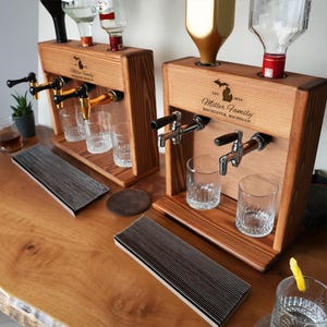 a wooden bar with a variety of drink dispensers, including beer taps and shot glasses, arranged on a wooden table.