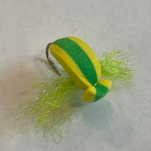 May include: A yellow and green foam fly fishing lure with a green and yellow marabou tail.