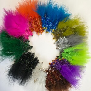 May include: A collection of 12 colourful fly fishing lures with feathers and beads. The lures are arranged in a circle on a white background.