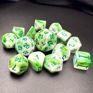 May include: A collection of polyhedral dice in various shapes, including D4, D6, D8, D10, D12, and D20. The dice are white with a green, marbled pattern and green numbering. Ideal for tabletop gaming.