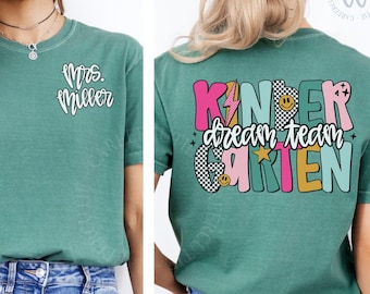 Op de afbeelding: Lichtgroen T-shirt met de tekst "Mrs. Miller" op de voorkant en "Kinder Dream Team Garten" op de achterkant. Het ontwerp op de achterkant heeft kleurrijke tekst, een bliksemschicht, sterren en smiley gezichten. Een comfortabele, casual stijl.