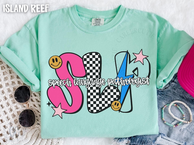 May include: A light green t-shirt with the text "SLP Speech Language Pathologist" in a colorful design. The design includes a pink "S", a checkered "L", and a blue lightning bolt for the "P". Smiley faces and stars are also included.