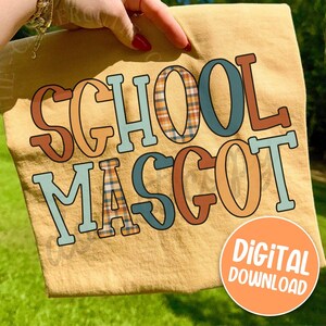 May include: A tan fabric with the words "SCHOOL MASCOT" in a retro font. The letters are outlined in brown, with plaid and solid color fills. A round orange "DIGITAL DOWNLOAD" sticker is in the lower right corner.