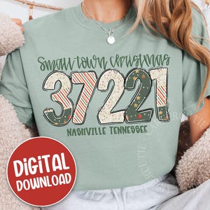 May include: A light green t-shirt with the text "Small Town Christmas" above the numbers "37221" and the words "Nashville Tennessee". The numbers are decorated with Christmas patterns. A red circle with "DIGITAL DOWNLOAD" is in the lower left.