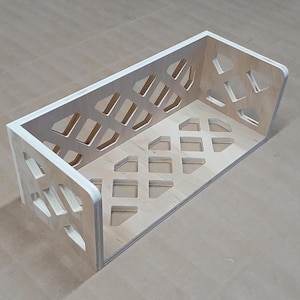 May include: A wooden shelf with a geometric design. The shelf is made of light wood and has a white painted edge. The shelf is empty.
