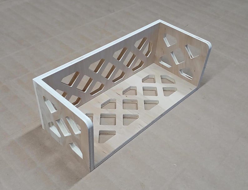 May include: A wooden shelf with a geometric design. The shelf is made of light wood and has a white painted edge. The shelf is empty.