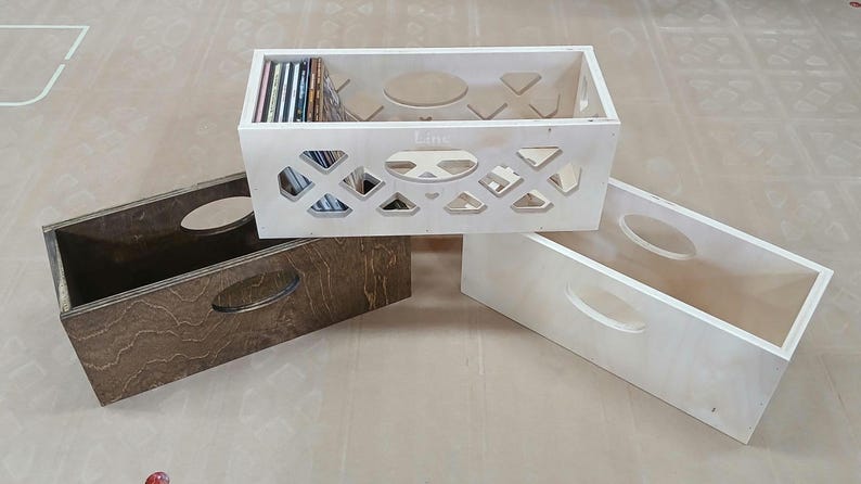May include: Three wooden record crates, one with a cutout design and the word "Lime" on the front, and two with solid fronts. The crate with the cutout design is filled with vinyl records.