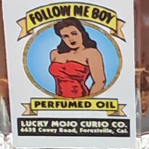 May include: A vintage-style illustration of a woman in a red dress with the text "FOLLOW ME BOY" and "PERFUMED OIL" on a yellow banner. The text "LUCKY MOJO CURIO CO. 6639 Covey Road, Forestville, Cal" is below the illustration.