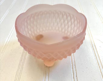 May include: A pink frosted glass bowl with a diamond pattern and three feet.
