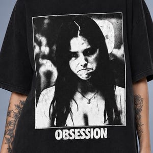 Obsession-Shirt, Nikki Freeman Grafik-T-Shirt, Vintage-Thriller-Obsession-Film-T-Shirt, Psychodrama-Film-Merchandise, Retro-Ästhetik-T-Shirt